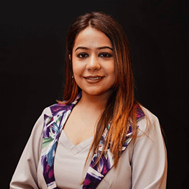 A smiling woman with long brown hair smiles at the camera.
